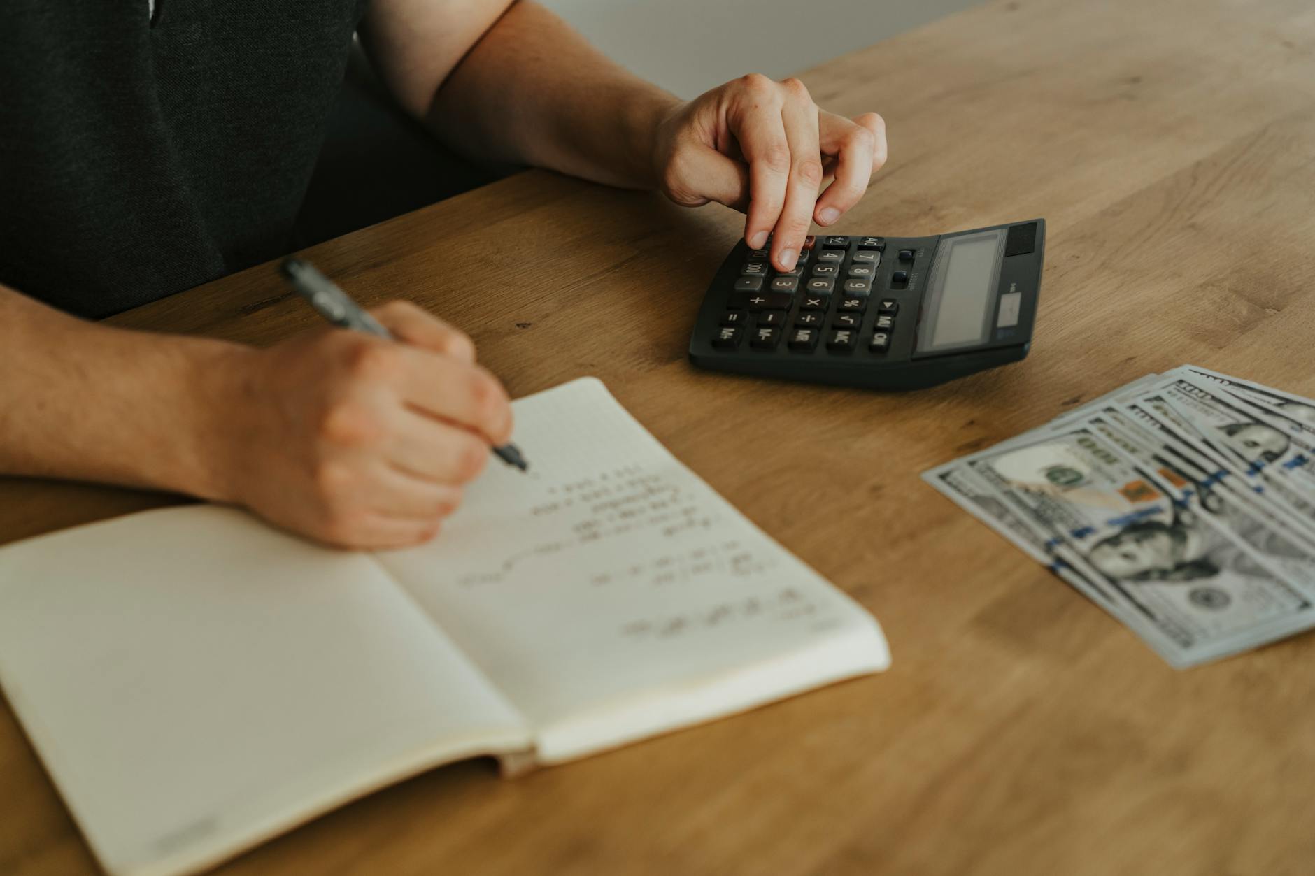 a person writing on white notebook